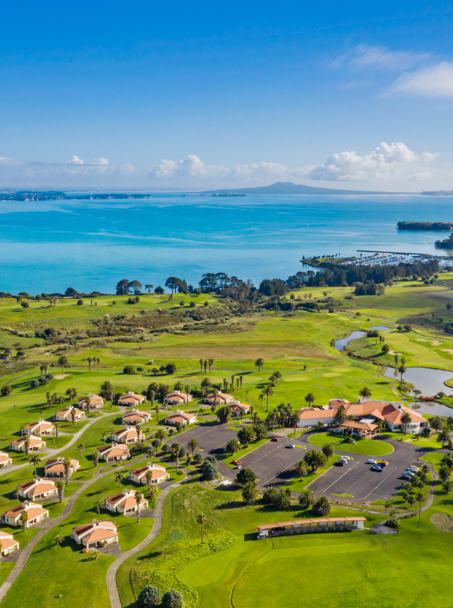 Rydges Formosa Auckland Golf Resort's Mediterranean-inspired villas and golf course, with main buildings, overlooking the Hauraki Gulf.
