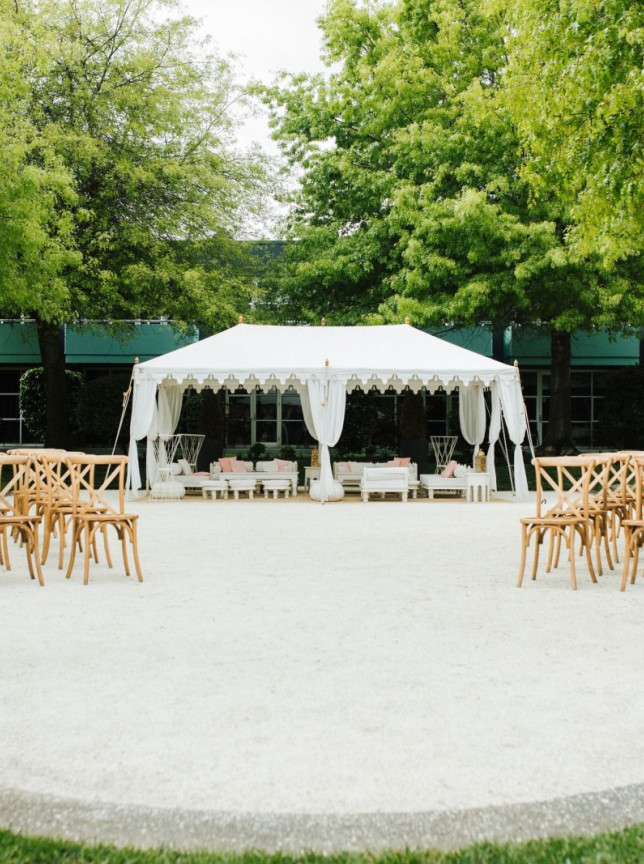 A customizable outdoor Marquee space with a white tent and wooden chairs at the boutique Naumi Auckland Airport.