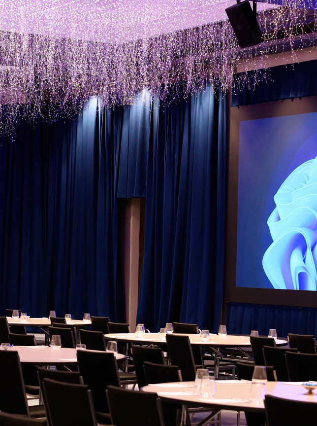 A conference setup at the Grand Millennium Auckland's ballroom, illuminated by its unique Sky Garden LED lighting sculpture.