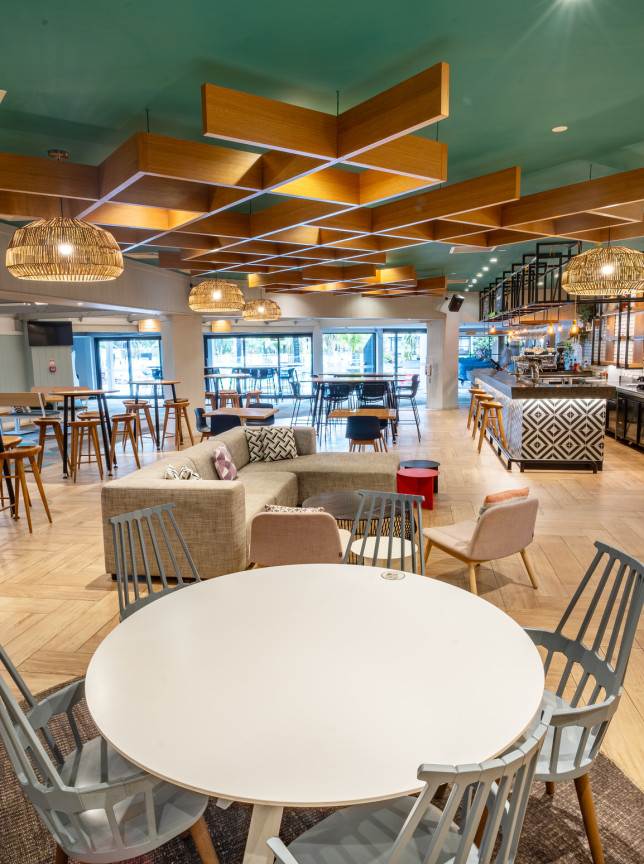 Holiday Inn Auckland Airport's modern lounge and bar features Pacific-inspired design with natural timber and woven textures.
