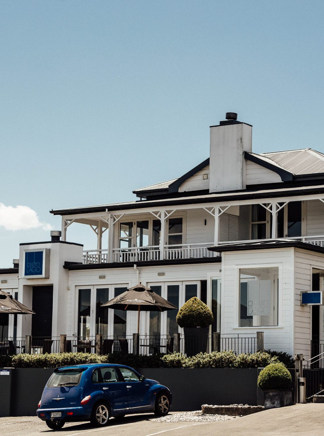 The white, Victorian-inspired heritage exterior of Hilton Lake Taupo hotel in Taupo, with an outdoor dining terrace.