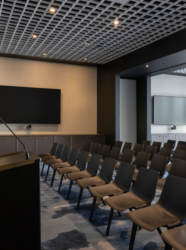 A sleek presentation room at Auckland's Commercial Bay Meeting and Event Suites, showcasing a modern, sophisticated design.