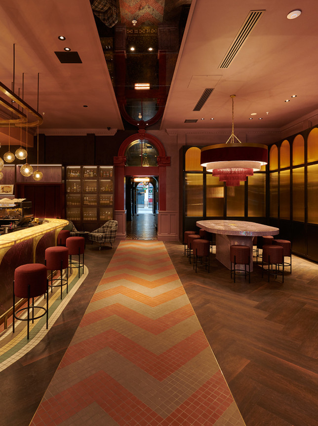 The Lola Rouge Grand Bar at Naumi Hotel Wellington, showcasing a richly colored and eclectic maximalist interior with a glowing bar and unique seating.