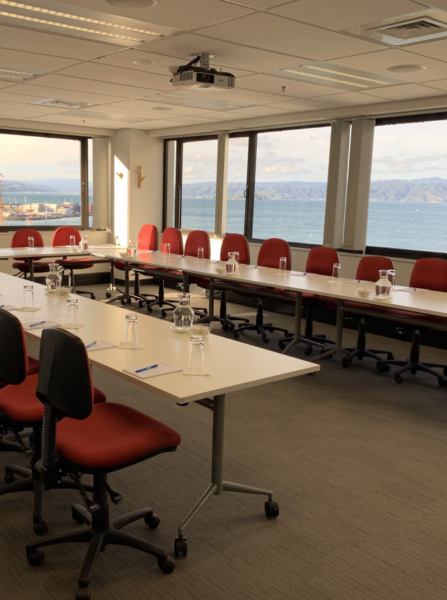 A bright, modern conference room at Willeston Conference Centre, Wellington, featuring a U-shaped table and harbor views.