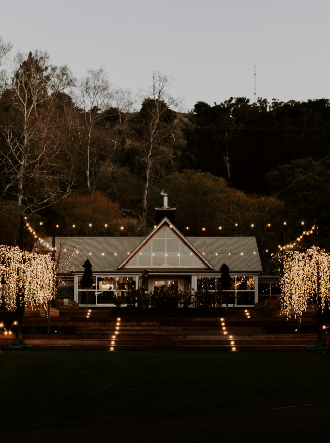 Glenfalloch Garden Cafe & Restaurant, an elegant chalet in Dunedin's historic gardens, glows with festive lights for events.