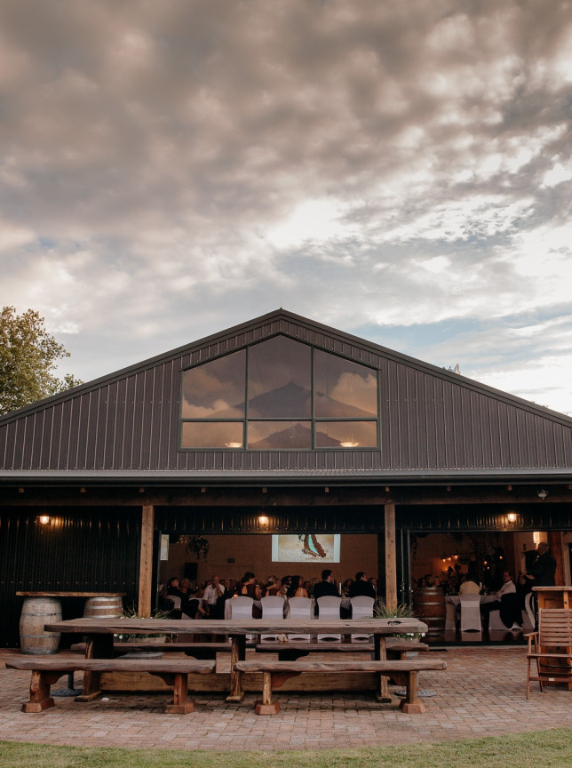 Guests enjoy an outdoor reception at the modern barn-style Eagle Ridge country estate in Tauranga.