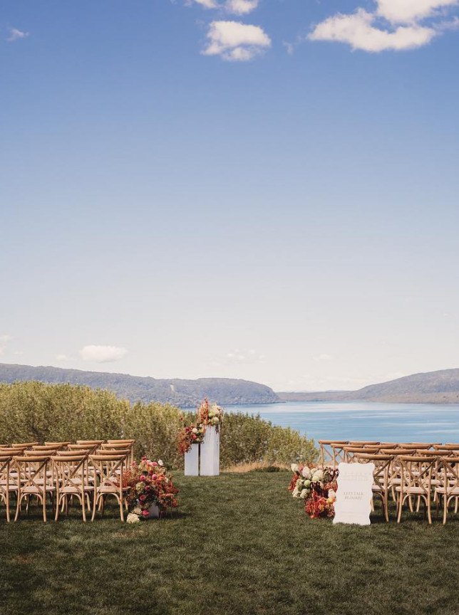An outdoor ceremony at The Black Barn in Rotorua, a rustic barn venue with stunning Lake Tarawera views.