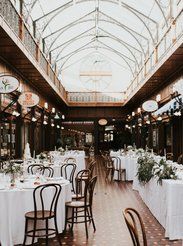 An elegant dining reception in The Tannery Christchurch's opulent Victorian-era Atrium, featuring arched glass and shopfronts.