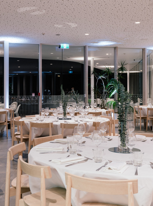 A modern banquet in Te Puna, Auckland Zoo's glass-walled event space, offering lush views of its natural environment.
