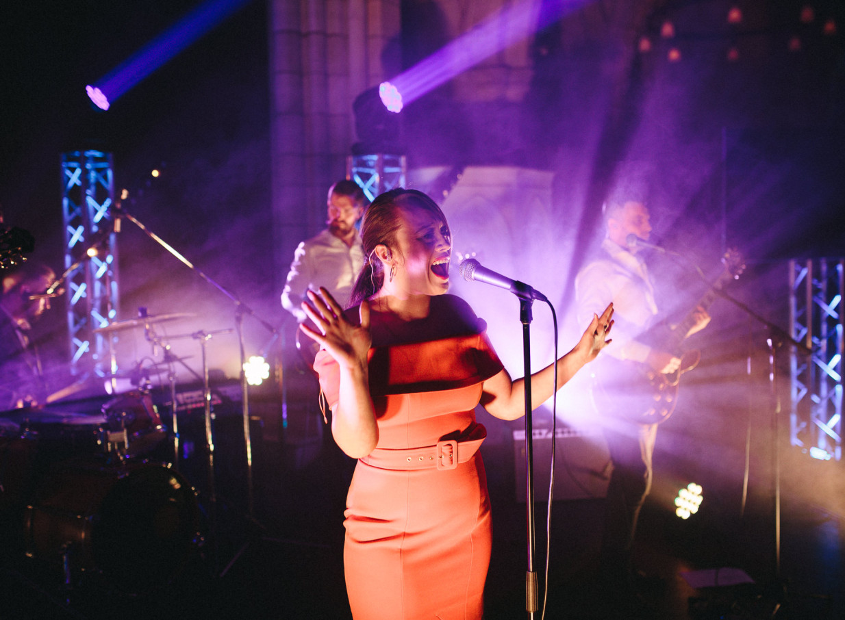 Auckland's Blue Steel band features a passionate vocalist performing on a stage with vibrant purple atmospheric lighting.
