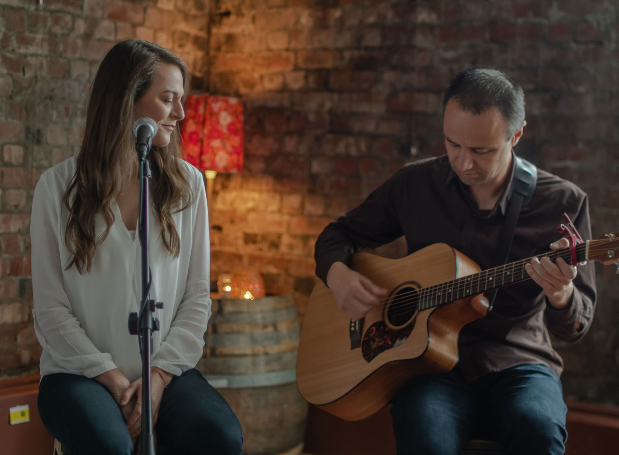Mish & Wade perform soulful live music in an intimate, rustic setting with exposed brick walls in Auckland.