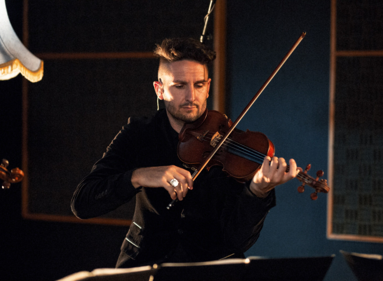 An Auckland Black Quartet musician plays violin, embodying their contemporary classic ensemble style.