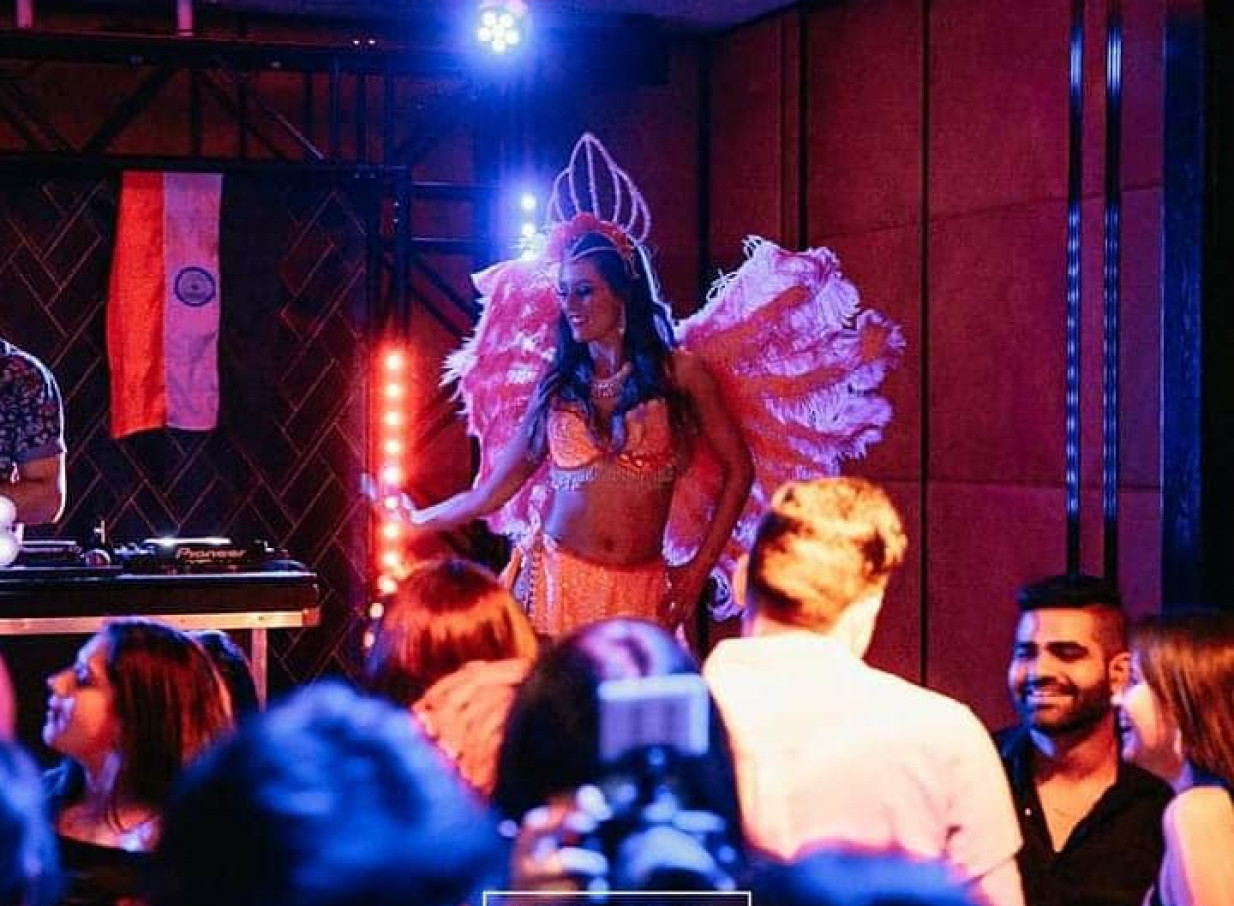 A vibrant stage show featuring a feathered performer by Finesse Entertainment in Auckland.