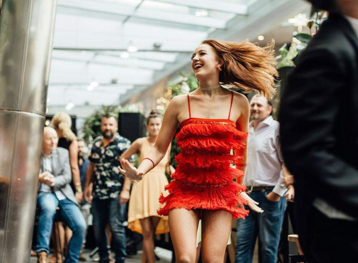 A Finesse Entertainment dancer performs a lively Latin-style routine in a modern Auckland event space.