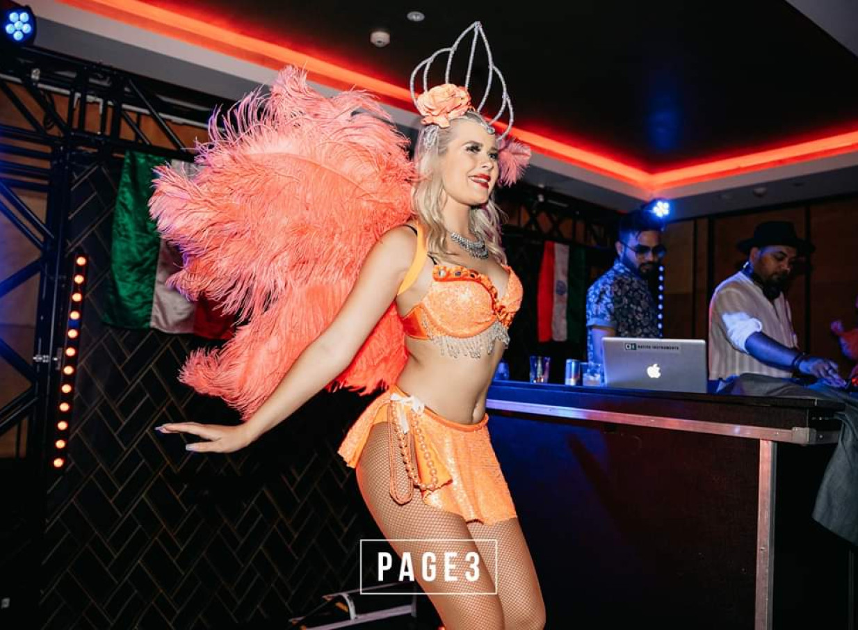 A dazzling showgirl performer from Finesse Entertainment Auckland enlivens an event with a vibrant feathered costume.