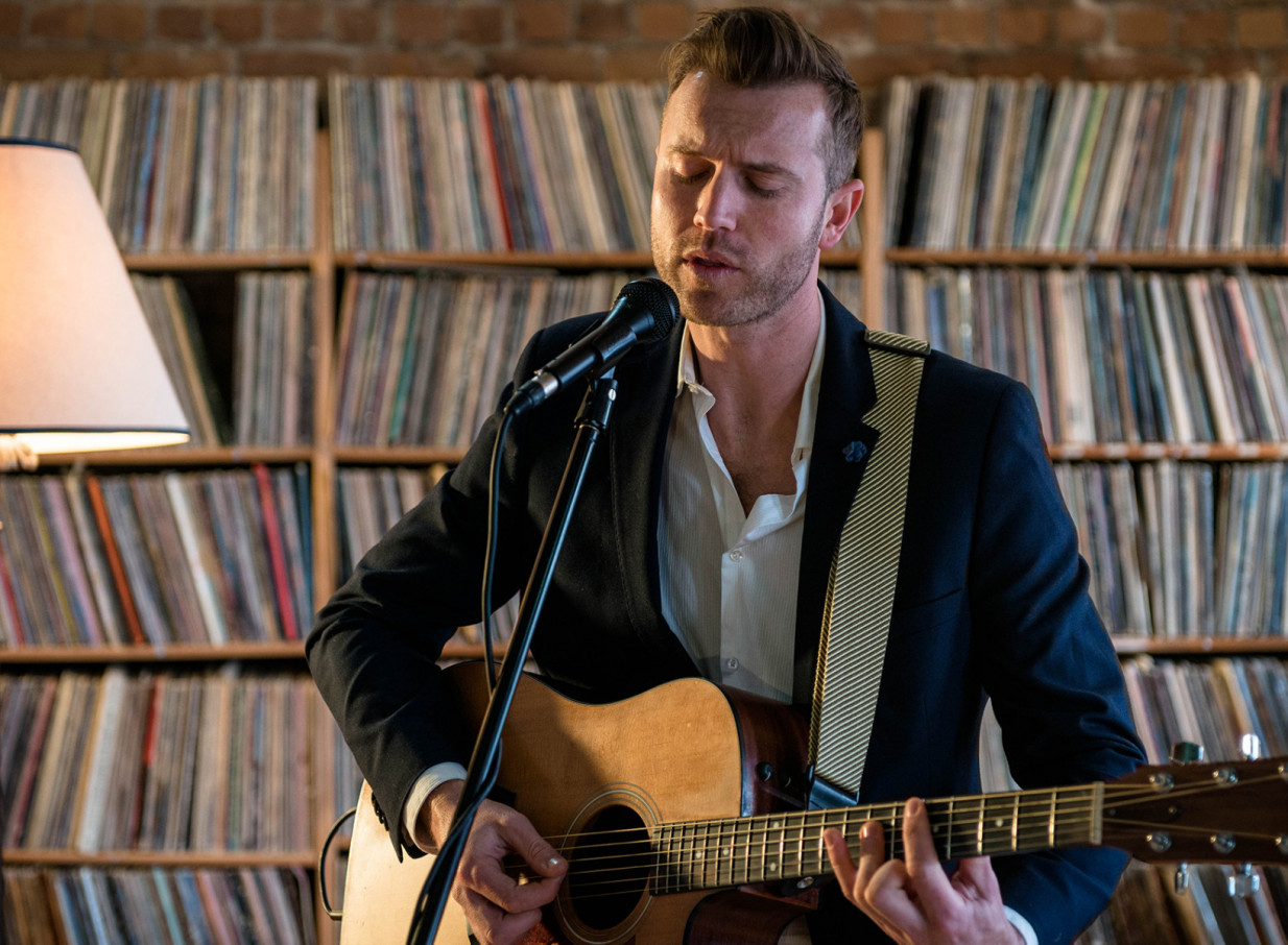 Auckland's Daniel John performs soulful acoustic music in a cozy, music-rich setting surrounded by vintage records.