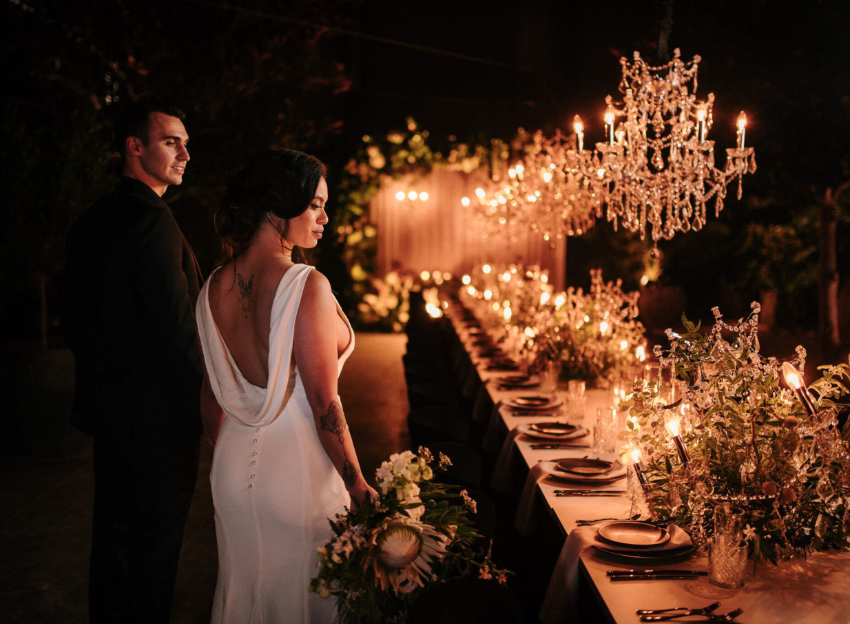 Zahn captures an elegant outdoor evening wedding reception in Auckland, featuring sparkling chandeliers and romantic candlelight.