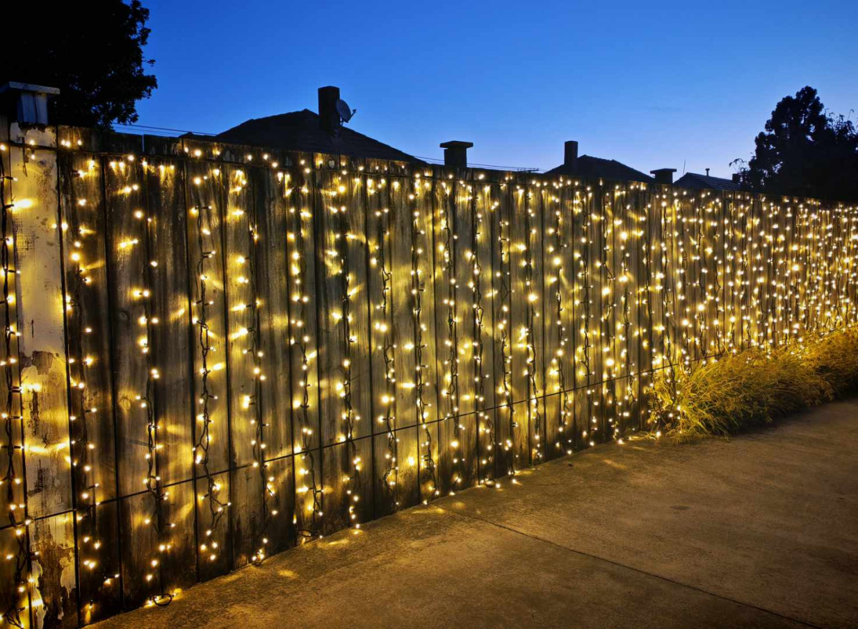 Light and Leaf Co. creates a warm, ambient Auckland outdoor setting with string lights draped across a wooden fence.