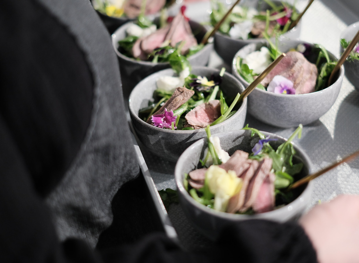 Elegantly presented individual servings of sliced meat, greens, and edible flowers, showcasing LittleWolf's on-trend catering in Auckland.