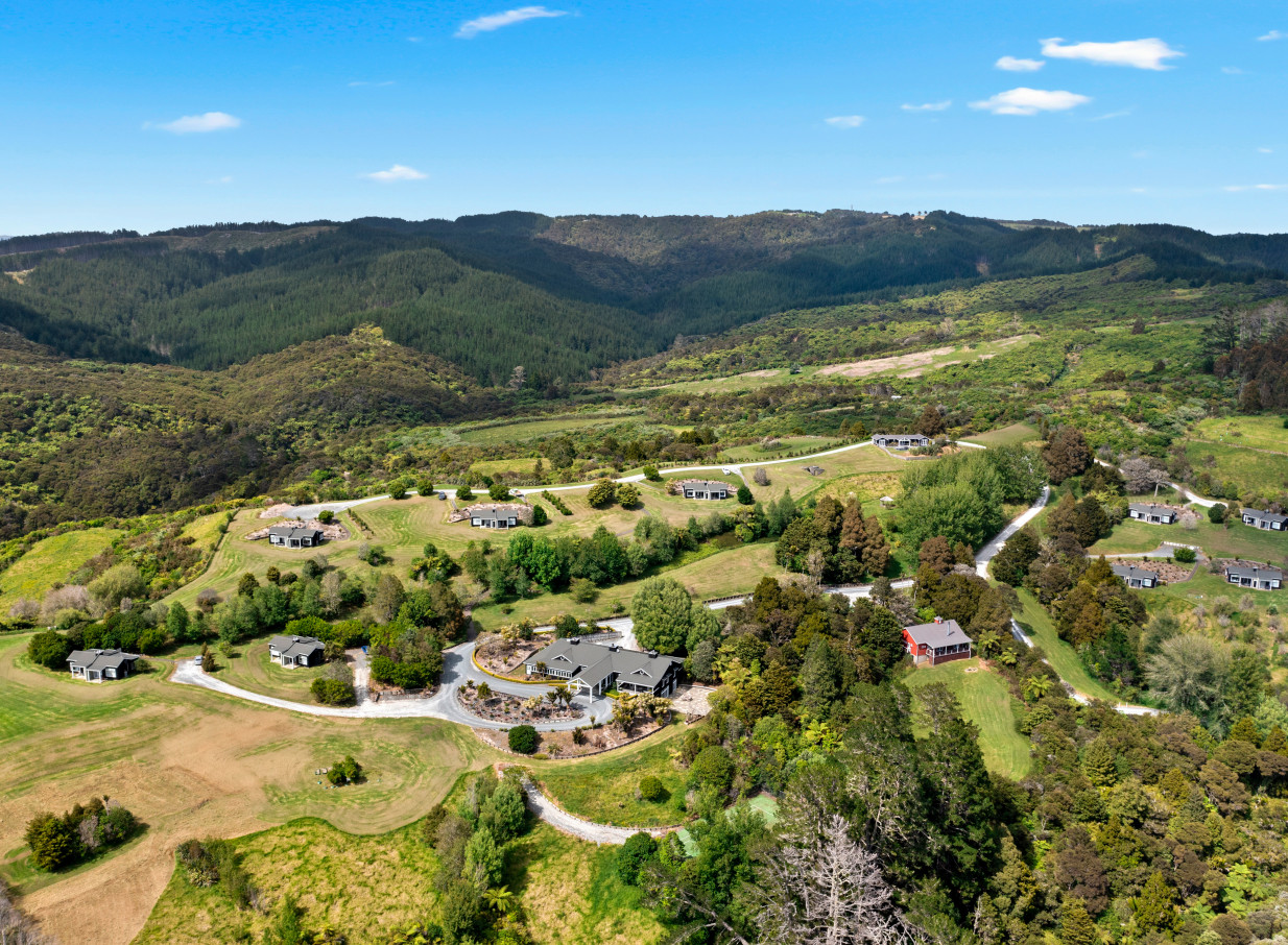 Aerial view of the contemporary Woodhouse Mountain Lodge in Auckland, featuring stylish villas nestled in a lush, mountainous landscape.