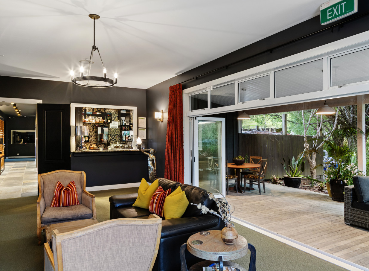 The elegant, modern lounge and bar at Woodhouse Mountain Lodge in Auckland opens onto a spacious outdoor patio.