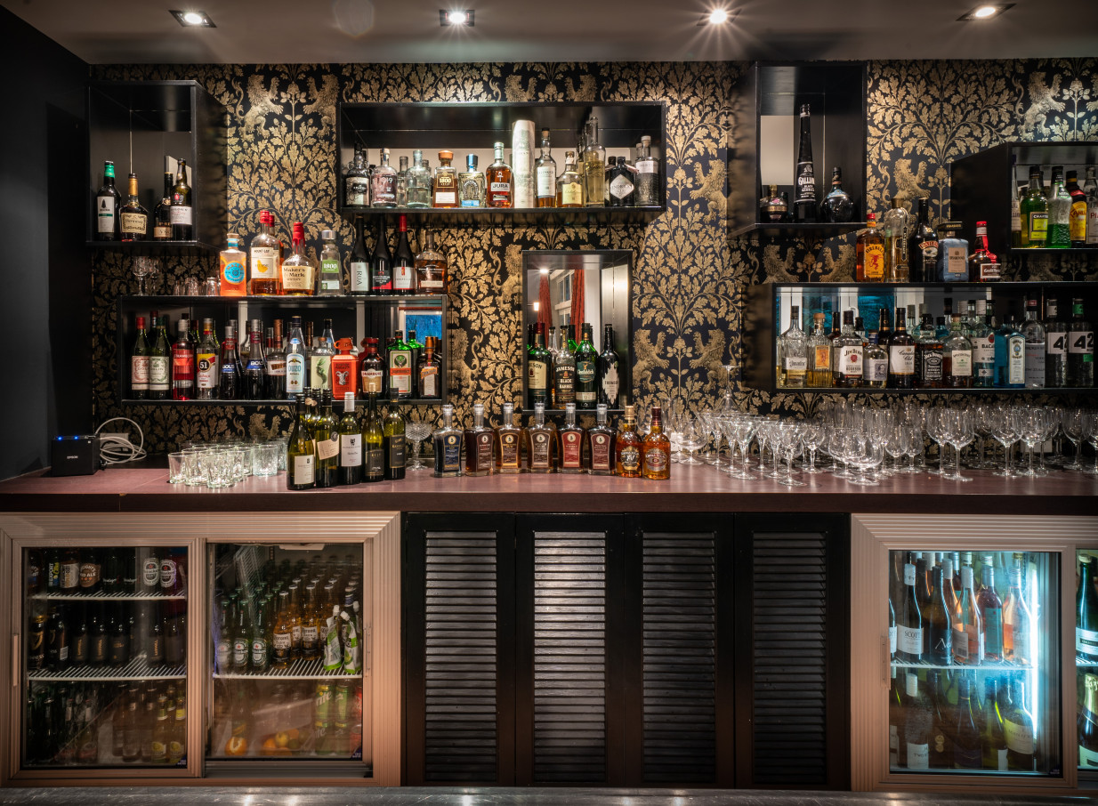 The stylish bar at Woodhouse Mountain Lodge in Auckland boasts patterned wallpaper and a diverse selection of spirits.
