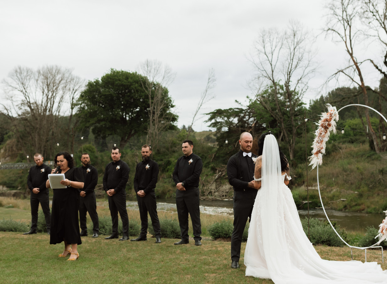 An outdoor wedding ceremony with a decorative arch at Omatua, a scenic riverside venue in Hawke's Bay.