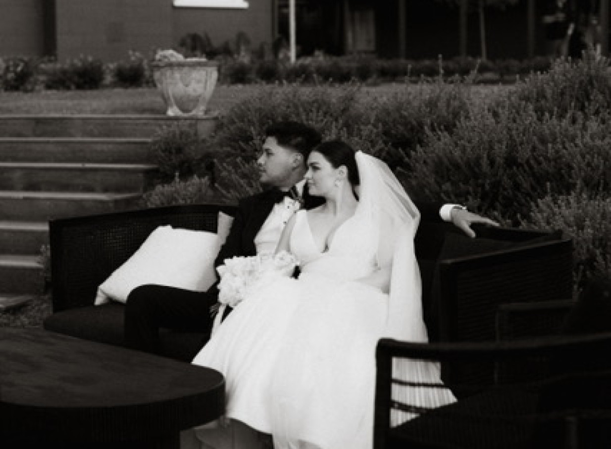 A newlywed couple relaxes on an outdoor sofa at the rural riverside Omatua lodge in Hawke's Bay.