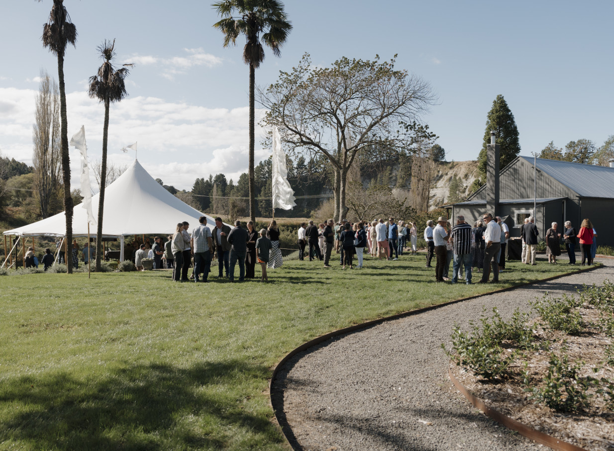 An outdoor event with a white marquee on the expansive lawns of Omatua, a rural riverside venue in Hawke's Bay.