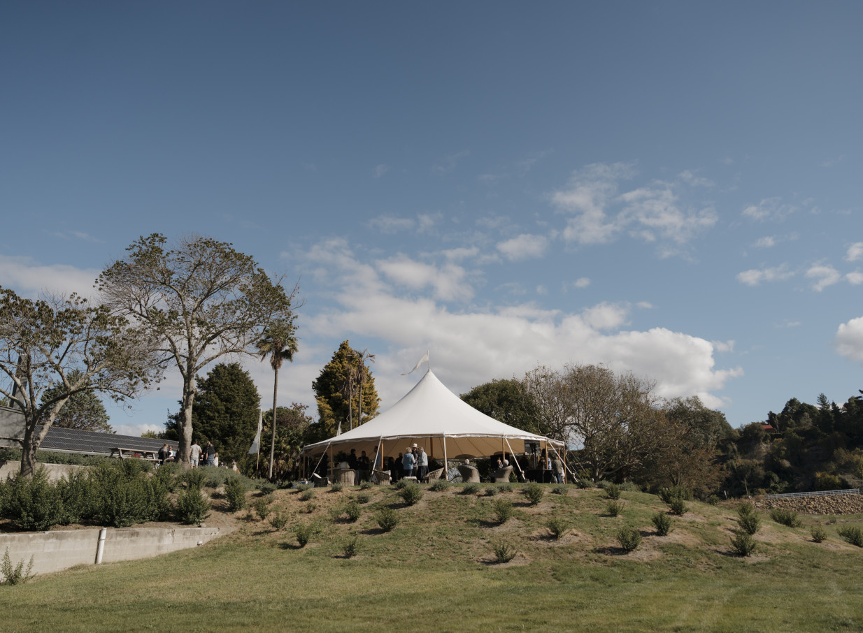 Guests enjoy an outdoor event under a white marquee at Omatua, a rural retreat in Hawke's Bay.