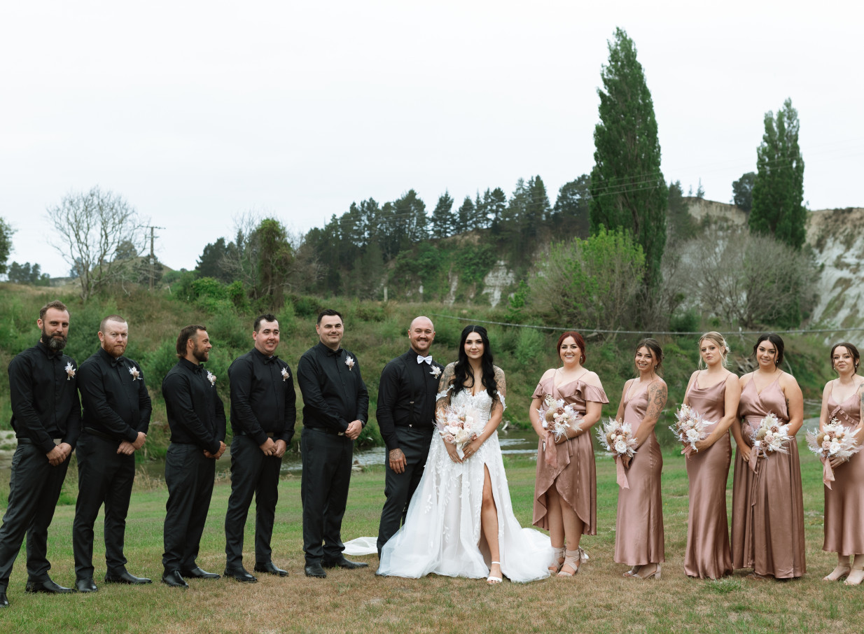 A wedding party gathers in the picturesque rural gardens of Omatua, a Hawke's Bay riverside venue.
