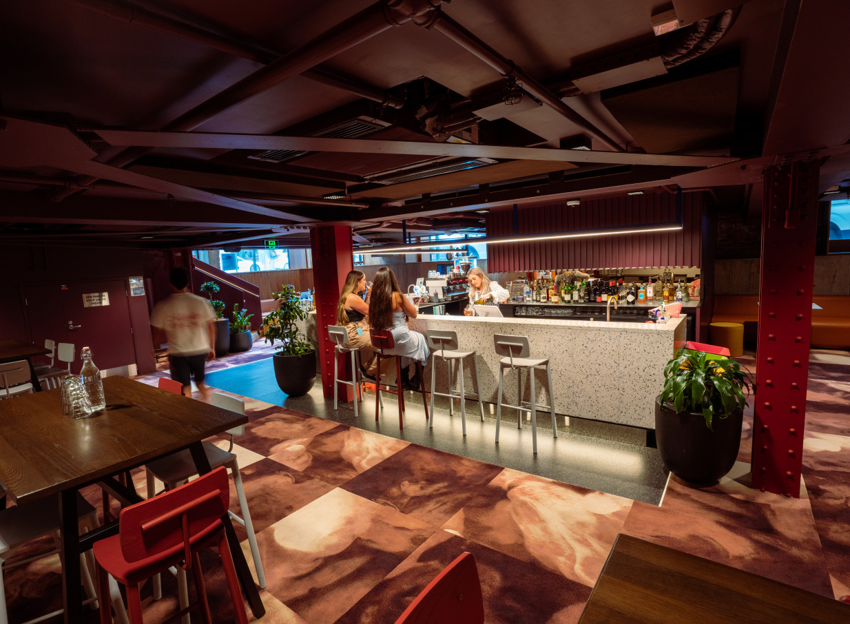 Guests enjoy the sleek, contemporary bar within 30 Waring Taylor St by Precinct Flex, a refurbished Art Deco building in Wellington.