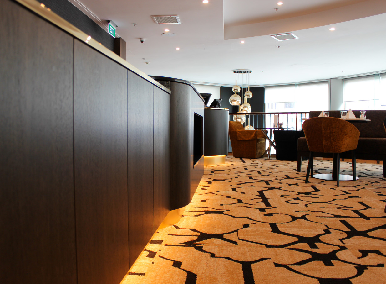 A contemporary lobby lounge with dark wood accents and modern furnishings at the elegant Bolton Hotel in Wellington.