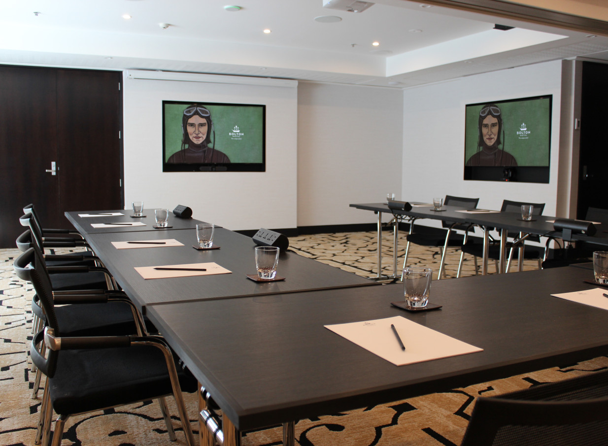 A modern and intimate meeting room at the Bolton Hotel, Wellington, ready for business with integrated screens.