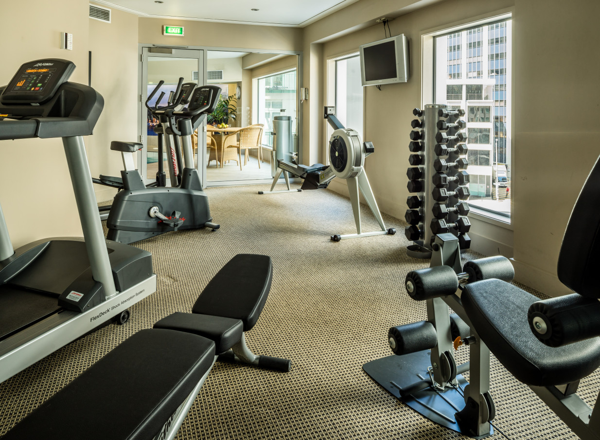 The elegant, contemporary fitness center at Bolton Hotel in Wellington, featuring various modern exercise machines and weights.