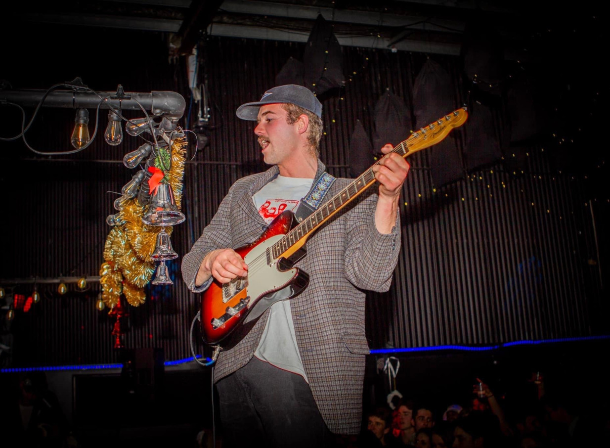 A musician rocks out on stage at Westend, a vibrant nightclub-style live music venue in Christchurch.
