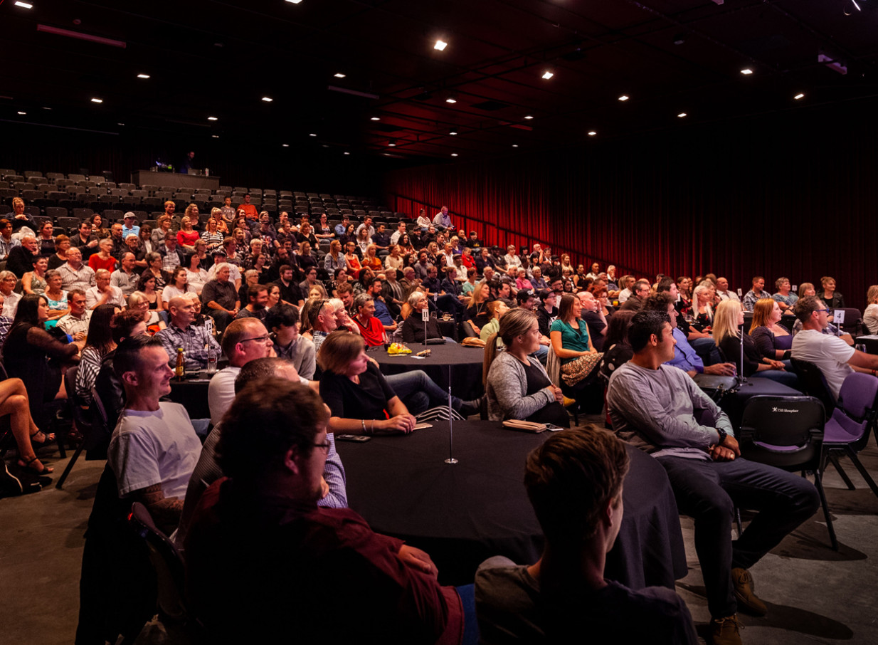 A vibrant audience gathers in a multi-purpose auditorium at New Plymouth's historic TSB Showplace, set for a performance.