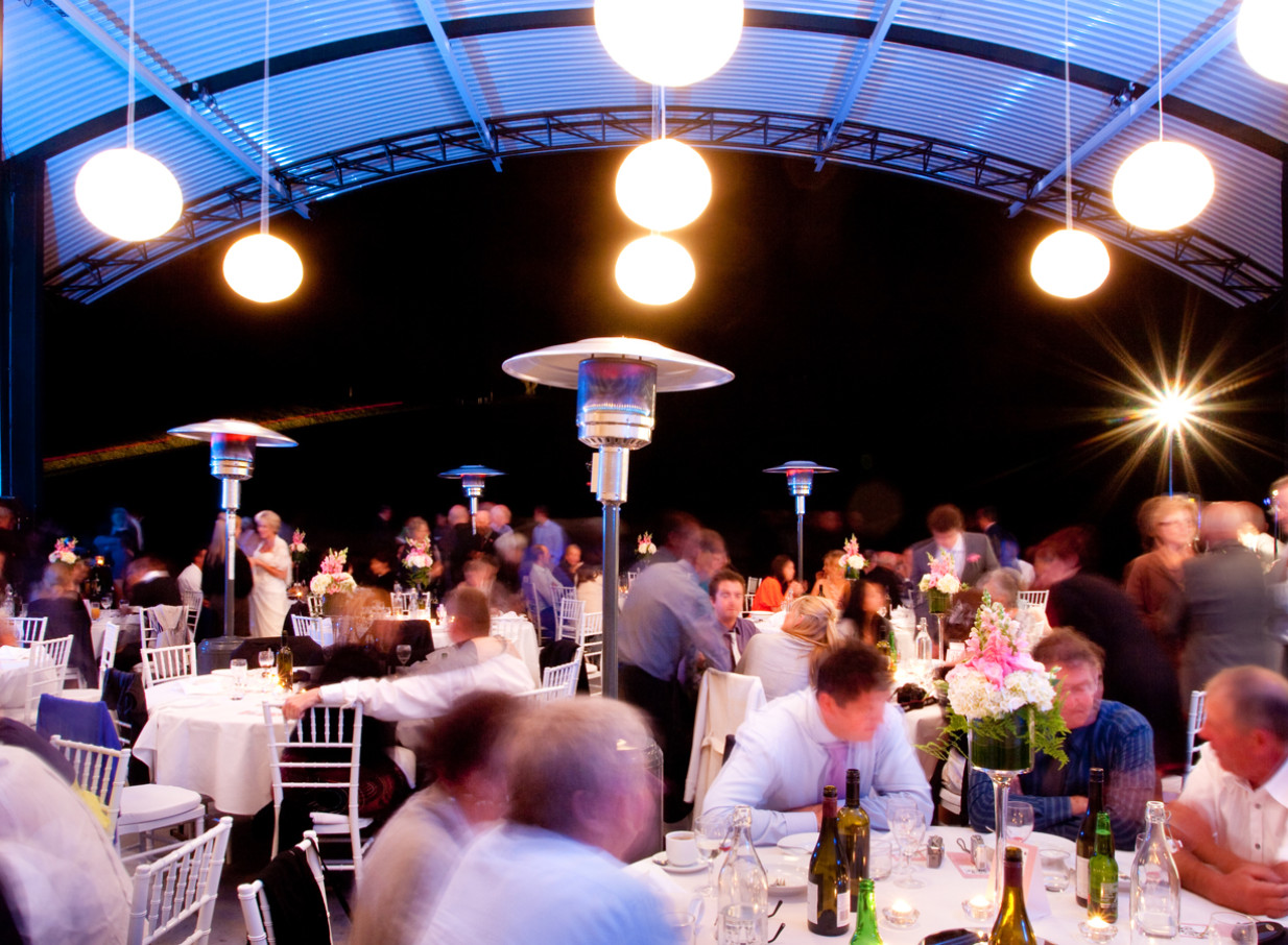 Guests enjoy an elegant covered outdoor dinner at Bowl of Brooklands, New Plymouth, an iconic natural amphitheatre.