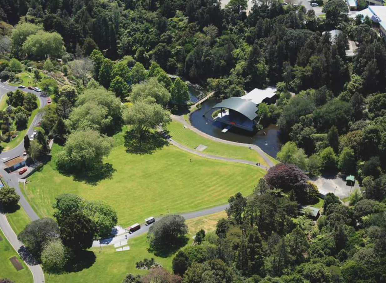 The natural grass amphitheater and stage over the lake at Bowl of Brooklands, New Plymouth, a world-class outdoor concert venue.