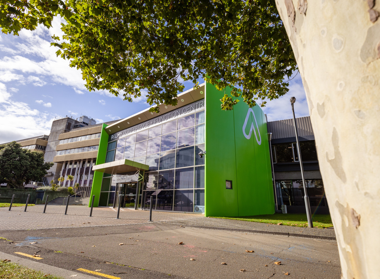 The modern exterior of Palmy Conference + Function Centre in Palmerston North, featuring bright green panels and glass.