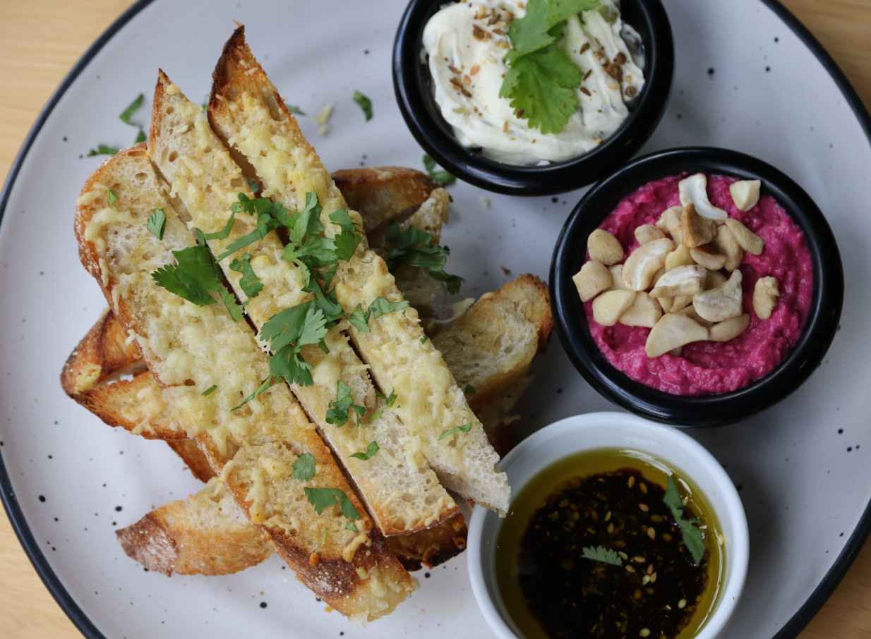 A sharing platter of toasted bread and dips, perfect for grazing at Rosanna's oasis-style garden bar in Auckland.
