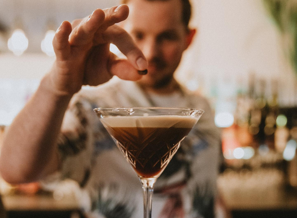A bartender garnishes an espresso martini in the lush garden cocktail bar at Rosanna's in Auckland.