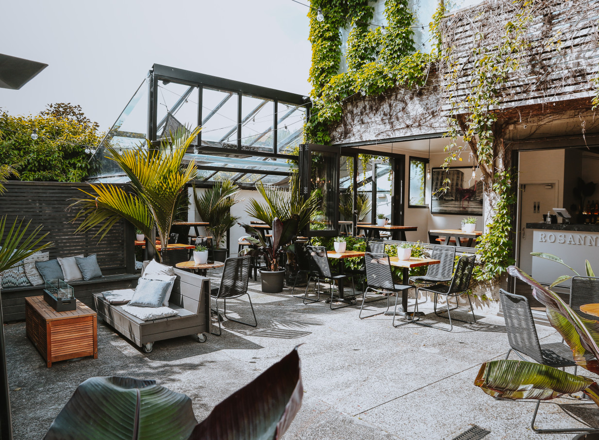 Rosanna's Garden Bar in Auckland features a lush, oasis-style outdoor courtyard with seating and a glasshouse conservatory.
