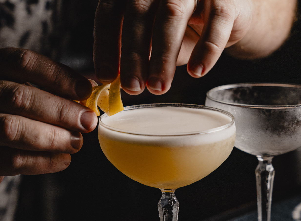 A hand garnishing a legendary cocktail at 39 Ponsonby, Auckland's eclectic Parisian-inspired bar.