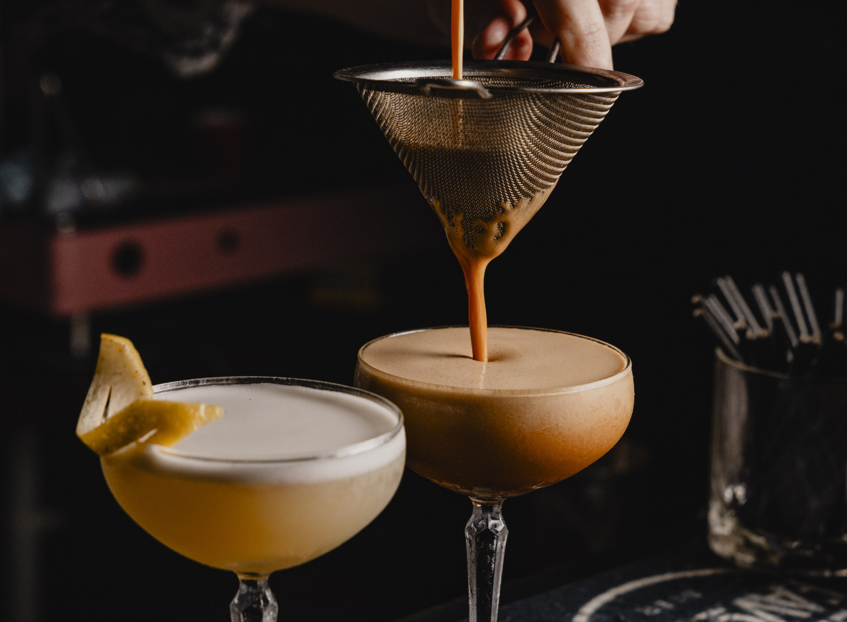 A bartender strains a cocktail in the Parisian-inspired bohemian bar at 39 Ponsonby, Auckland.