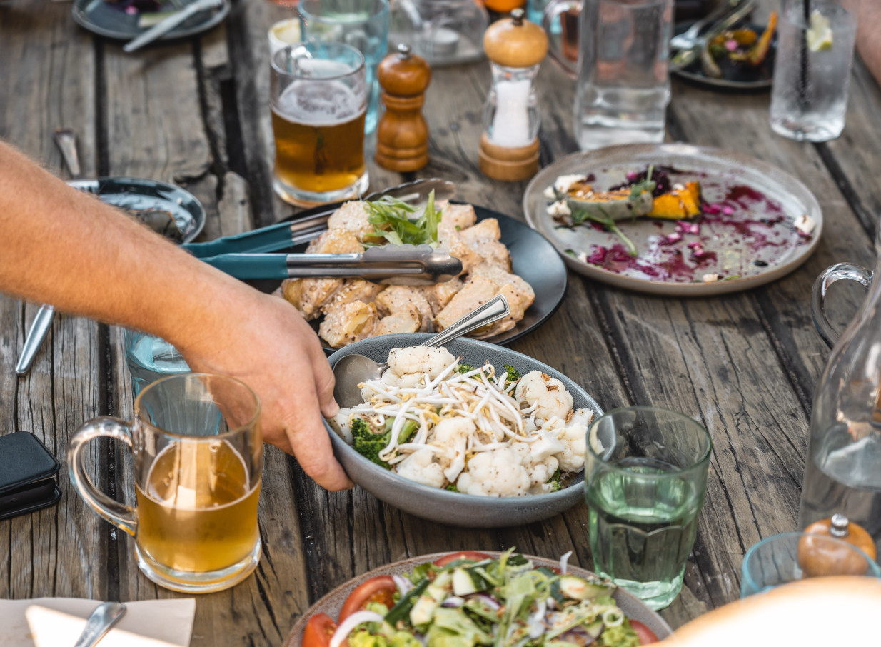 A shared meal with a rustic wooden table setting at 39 Ponsonby, Auckland's welcoming bohemian garden bar.