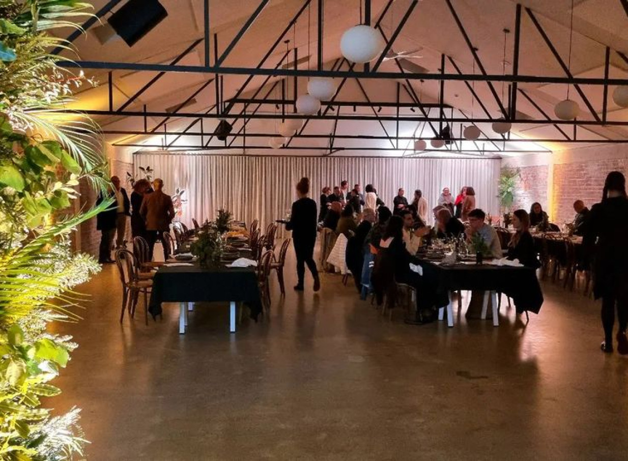 A lively dinner reception fills the industrial-chic event space of Whisky & Wood, Wellington.