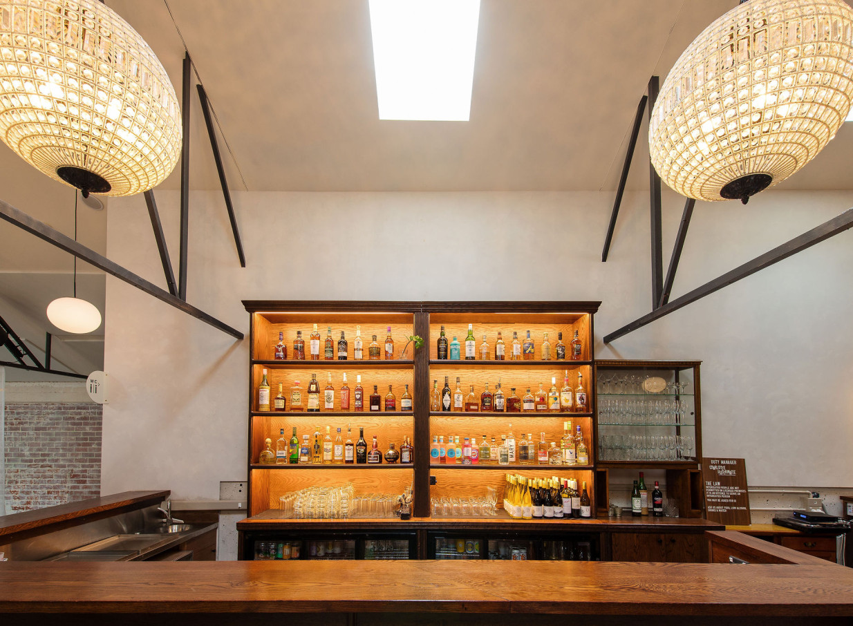 Whisky & Wood Wellington's industrial-chic bar area, with a wooden counter and dazzling chandeliers, offers a stylish setting.