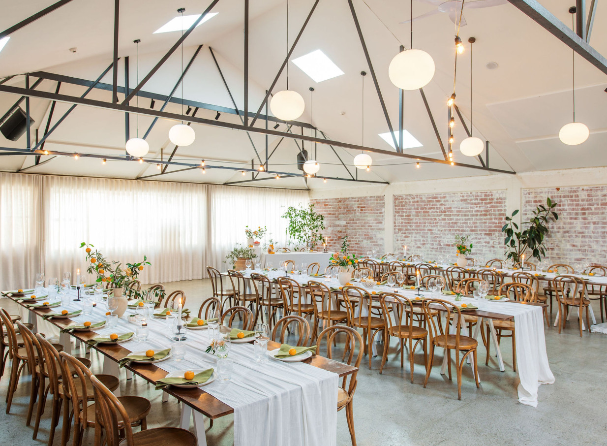 A New York loft-style event space with washed-brick walls and high ceilings, prepared for dining at Whisky & Wood, Wellington.
