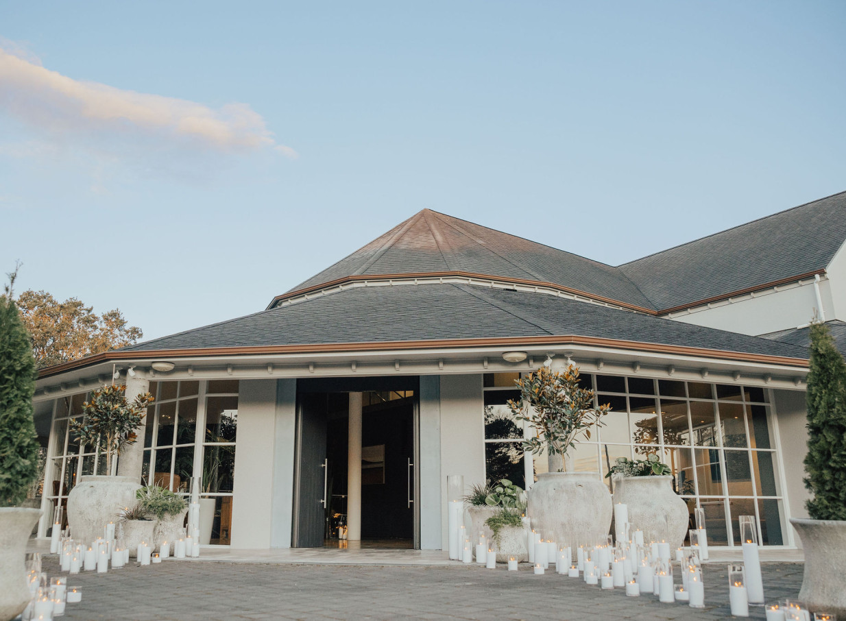 Candles light the welcoming entrance of the modern waterside event venue, Orakei Bay in Auckland.